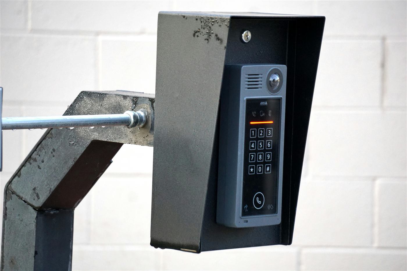 Outdoor video intercom keypad mounted in a protective metal housing.